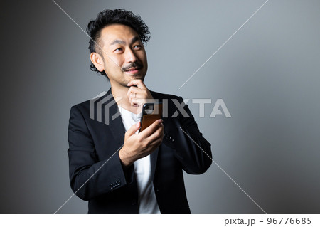 スマホを持つ髭の男性 96776685