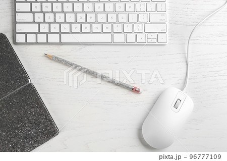 Flat lay composition with mouse and keyboard on white wooden table 96777109