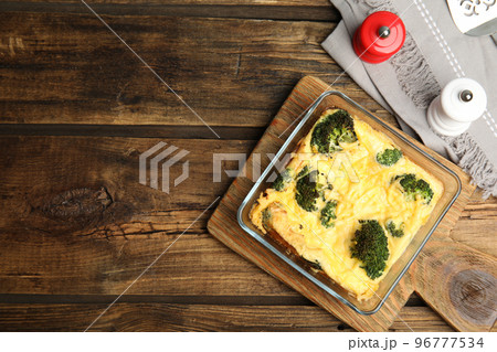 Tasty broccoli casserole in baking dish on wooden table, flat lay. Space for text 96777534