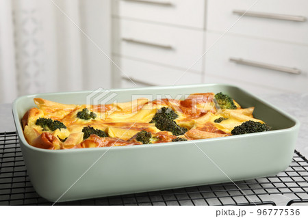 Tasty broccoli casserole in baking dish on cooling rack 96777536