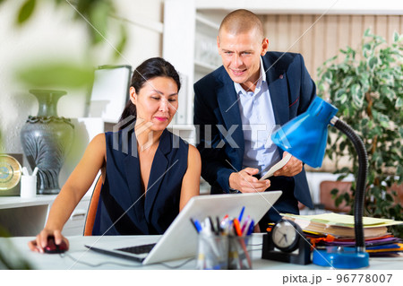 Two business colleagues working with laptop and papers in office Two business colleagues working with laptop and papers in office 96778007