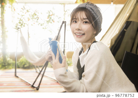おうちキャンプイメージ　テントの前で読書をする若い女性 96778752