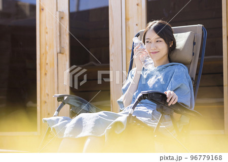 屋外サウナの前でサウナポンチョを着て外気浴をするサウナ女子 屋外サウナの前でサウナポンチョを着て外気浴をするサウナ女子 96779168