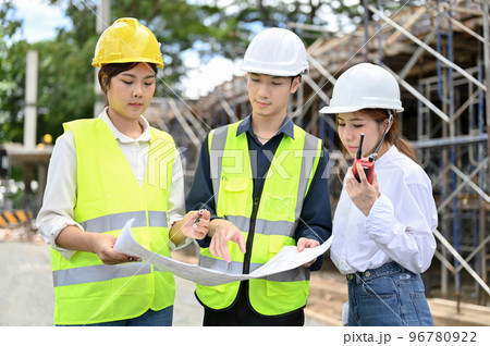 Female and male architects inspecting the building at the construction site. 96780922