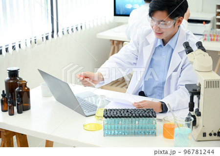 Handsome Asian male scientist or medical technician working in the laboratory. Handsome Asian male scientist or medical technician working in the laboratory. 96781244