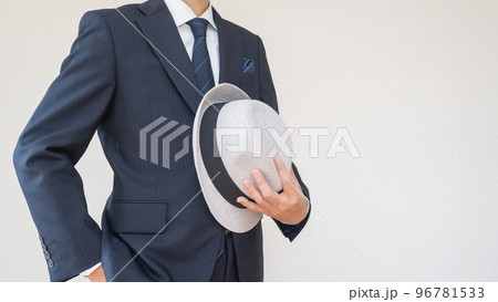 中折れ帽を持つスーツを着た男性 96781533