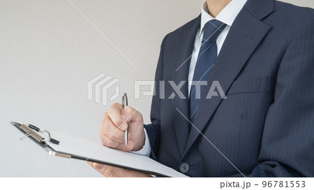 紙に書くビジネスマン｜クリップボードを持つ男性 96781553