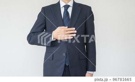 安心・おまかせポーズ｜スーツ姿で胸に手を当てる男性 96781665