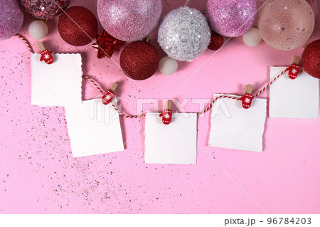 Pink and red Christmas tree balls and paper notes .The concept of the New Year, Christmas, holiday, postcards for the holidays. Copy space. Flat lay Pink and red Christmas tree balls and paper notes .The concept of the New Year, Christmas, holiday, postcards for the holidays. Copy space. Flat lay 96784203