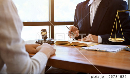 A successful male lawyer is giving advice and consulting to his client in the office. A successful male lawyer is giving advice and consulting to his client in the office. 96784625