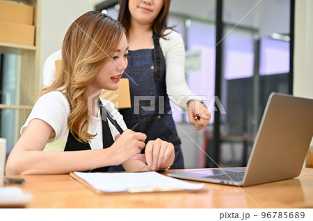 Asian female online business owner checking her online order on the website Asian female online business owner checking her online order on the website 96785689