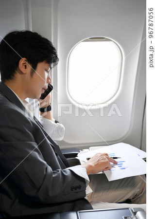 Portrait, Professional Asian businessman passenger having a business call during the flight Portrait, Professional Asian businessman passenger having a business call during the flight 96787056