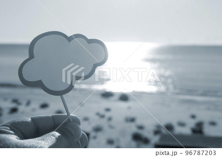 Stick with paper empty speech bubble on background blue sea, sky, sandy beach in hand on sunny summer day. Text-balloons with space for text. Concept, symbol, sign vacation travel tourism. Blue color Stick with paper empty speech bubble on background blue sea, sky, sandy beach in hand on sunny summer day. Text-balloons with space for text. Concept, symbol, sign vacation travel tourism. Blue color 96787203
