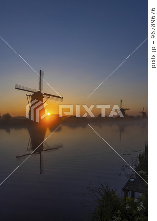 Traditional Dutch windmills with a colourful sky just before sunrise in Kinderdijk, The Netherlands Traditional Dutch windmills with a colourful sky just before sunrise in Kinderdijk, The Netherlands 96789676