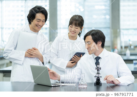 大学の研究室でノートパソコンを見ながら会話をする教授と学生 96791771