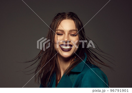 Happiness. Emotional young beautiful girl with artistic makeup laughing over grey background. Concept of beauty, magazine style and human emotions Happiness. Emotional young beautiful girl with artistic makeup laughing over grey background. Concept of beauty, magazine style and human emotions 96791901