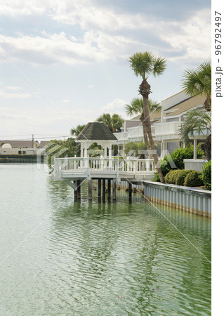 View of a gazebo on a deck over the brackish water of a lake with steel retaining wall at Destin, FL 96792497