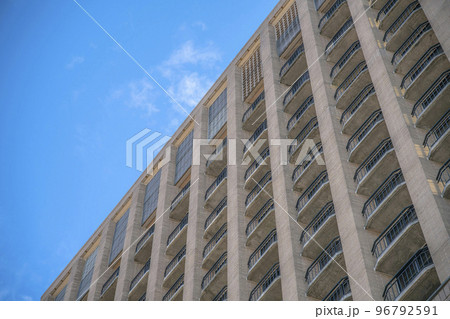 Exterior view of apartment units with balconies against clear blue sky 96792591