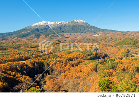 快晴の下、御嶽山展望台から望む冠雪の御嶽山と紅葉真っ盛りの開田高原 96792971