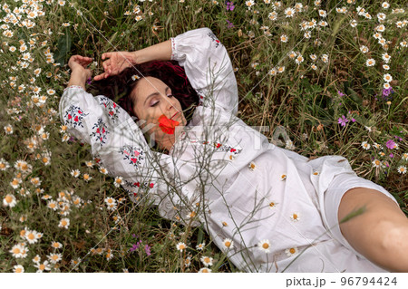 A beautiful woman lies on her back in a field and lifts up her beautiful legs. Good morning A beautiful woman lies on her back in a field and lifts up her beautiful legs. Good morning 96794424