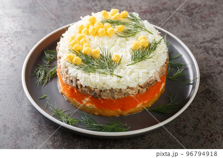 Classic mimosa salad with potatoes, canned fish, carrots, eggs and cheese seasoned with mayonnaise close-up on a plate. Horizontal Classic mimosa salad with potatoes, canned fish, carrots, eggs and cheese seasoned with mayonnaise close-up on a plate. Horizontal 96794918