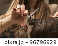 Barber shop men hairstyle. Young man getting a modern haircut. Girl hairdresser cuts a guy with 96796929
