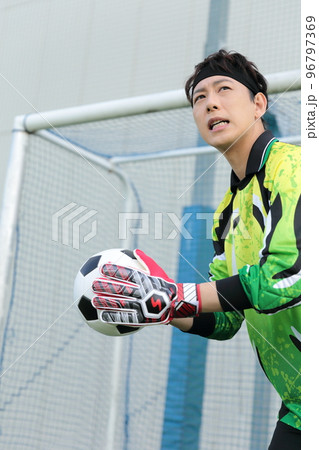 サッカーボールをキャッチするゴールキーパーの男性 96797369