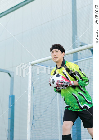 サッカーボールをキャッチするゴールキーパーの男性 96797370