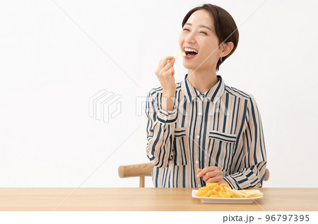 お菓子を食べる女性 96797395