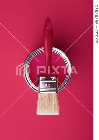 Can of viva magenta paint wirh brush on pink background. 96797831