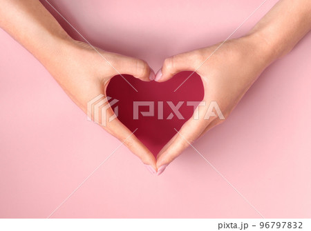 Demonstrating color of 2023 Viva Magenta. Female hands making heart. Love, friendship, peace concept. Valentine day, Birthday, Mothers Day. 96797832