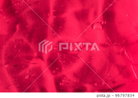Demonstrating color of 2023 Viva Magenta. Texture of transparent gel with air bubbles and waves. Concept of skin moisturizing, body care and prevention of viruses. Liquid beauty product closeup.  96797834