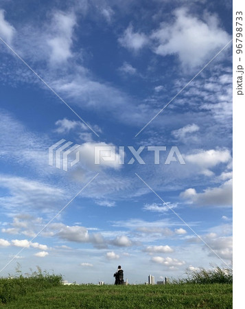 埼玉県川口市荒川堤からの空模様(土手上を行く親子と浮ぶ雲） 96798733