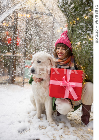 Woman with dog celebrates winter holidays 96798931