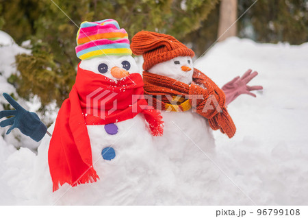 A couple of snowmen in hats and scarves. Winter fun. 96799108