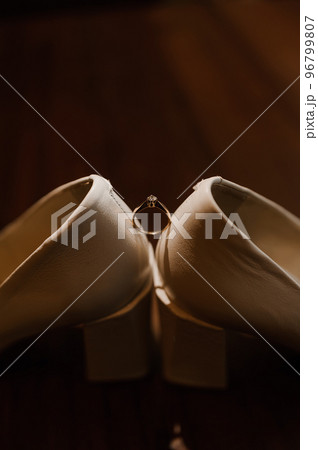 Ring with a stone on white women's leather shoes. Bride's accessories, bride's morning Ring with a stone on white women's leather shoes. Bride's accessories, bride's morning 96799807