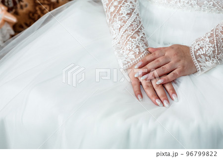 Bride's hands on white wedding dress 96799822