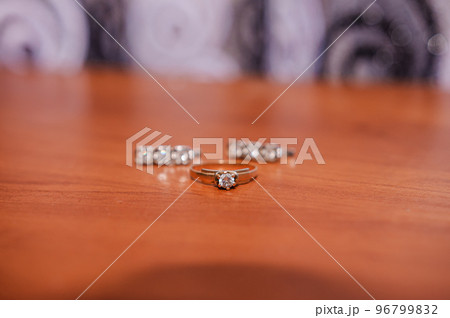Earrings, gold ring with a gem on a brown background 96799832