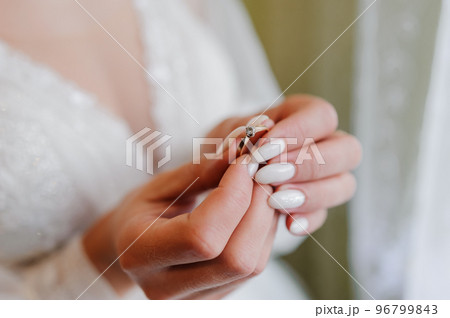 Gold ring with a diamond on the bride's hand. Ring with a stone on a woman's hand 96799843