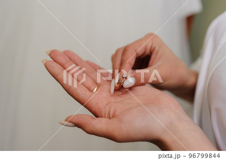 Gold ring with a diamond on the bride's hand. Ring with a stone on a woman's hand Gold ring with a diamond on the bride's hand. Ring with a stone on a woman's hand 96799844