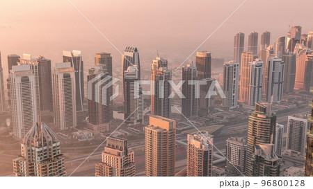 JLT skyscrapers and marina towers near Sheikh Zayed Road aerial timelapse during sunrise. Residential buildings JLT skyscrapers and marina towers near Sheikh Zayed Road aerial timelapse during sunrise. Residential buildings 96800128