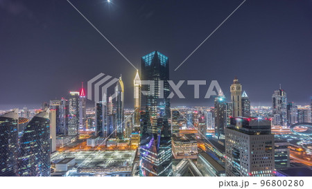 Panorama of futuristic skyscrapers in financial district business center in Dubai all night timelapse Panorama of futuristic skyscrapers in financial district business center in Dubai all night timelapse 96800280