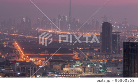 Dubai Downtown skyline row of skyscrapers with tallset tower aerial night to day timelapse. UAE 96800558