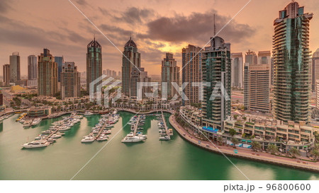 Sunrise over Dubai Marina luxury tourist district with skyscrapers and towers around canal aerial timelapse Sunrise over Dubai Marina luxury tourist district with skyscrapers and towers around canal aerial timelapse 96800600