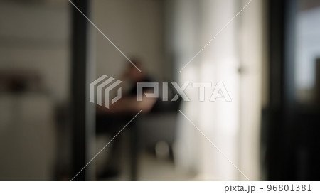 Blurred background of one man sitting in diningroom with natural window light Blurred background of one man sitting in diningroom with natural window light 96801381