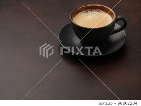 Large cup of fresh hot coffee with creamy foam on brown board. 96802204