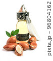 Argan oil in a oriental glass and metal bottle and argan nuts with green leaves isolated on white background. 96804162