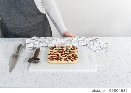 Scoring white chocolate cranberry pecan fudge for cutting into small pieces. 96804685