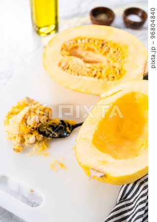 Preparing organic spaghetti squash with olive oil, salt, and pepper. 96804840