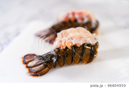 Preparing raw lobster tails to make garlic lobster tails. Preparing raw lobster tails to make garlic lobster tails. 96804950